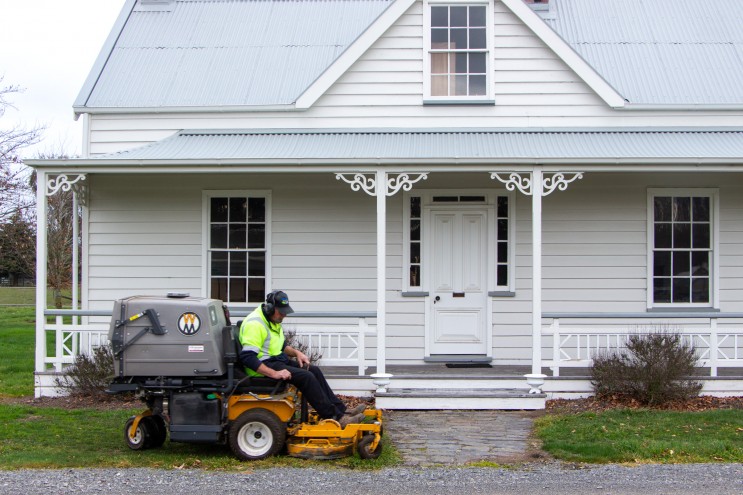 Ross mowing the front of a heritage home